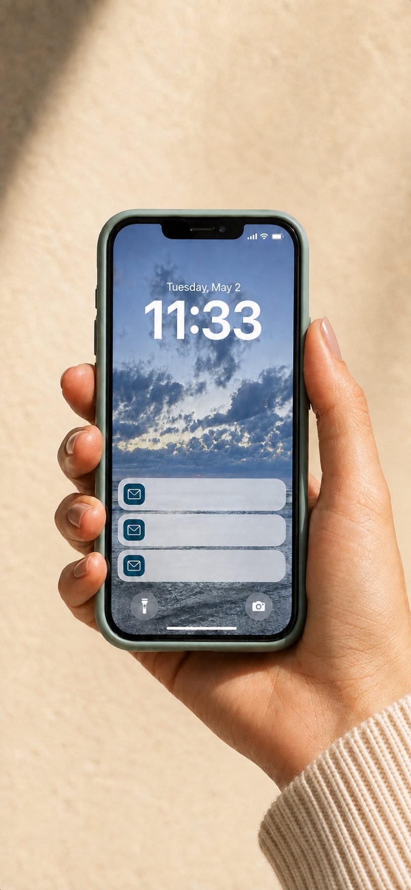 Hand hält Handy mit drei E-Mail-Benachrichtigungen auf dem Sperrbildschirm